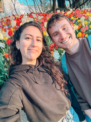 Happy couple taking a selfie in a tulip garden