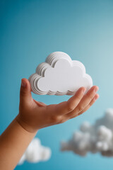 Child hand holding a stylized white cloud against a blue background, symbolizing cloud computing, imagination, and digital technology.