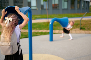 girls playing at playground with communication tubes, exploring outdoor fun and interaction. school...