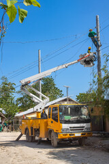 a team of electricians installs high-voltage electrical wires on poles