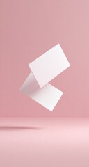 Two blank business cards float against a soft pink background