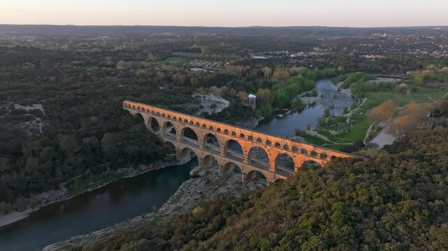Aerial view of Pont du Gard Roman aqueduct glowing at sunset in France
