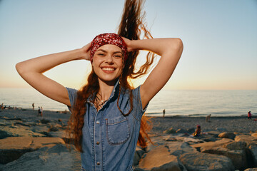 Lifestyle woman in modern boho-western denim street style smiling joyfully with flowing hair by the...