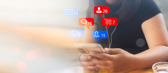 Woman hand hold smartphone and use social media network application to check new feedback or interactive with people and send emoticon for  react feeling and moment.