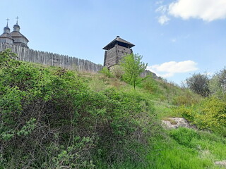 View from the foot of the hill on the ancient wooden fence surrounding the outbuildings of the Zaporizhian Sich.
