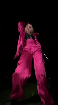 Young woman dancing waacking in a park at night
