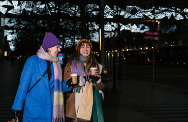 Happy friends having fun having coffee outdoors at Christmas, shopping concept