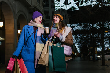 Two friends enjoy Christmas shopping and a coffee in the city centre.