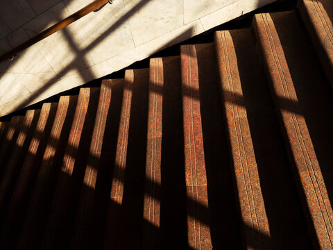 Staircase with shadow patterns in a well-lit interior space during daytime hours
