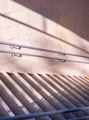 Fototapeta premium Staircase leading downward with interesting light and shadow play in an urban environment during early morning hours