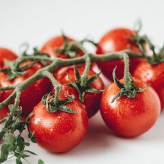 Fresh, vibrant red cherry tomatoes with green stems and leaves on a white background
