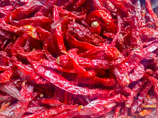 A pile of large dried red chilies dried in the sun during the day.