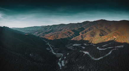 twisty road winds through mountain in andorra at sunset