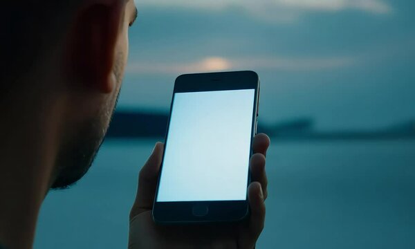 Close-up of a hand holding a smartphone with a green screen, ideal for mockups or visual effects in digital content and app design presentations