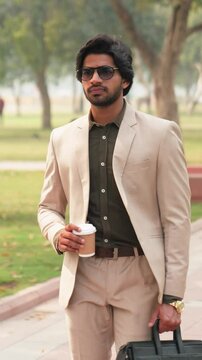 Vertical Video of Confident Indian Businessman Walking with Coffee