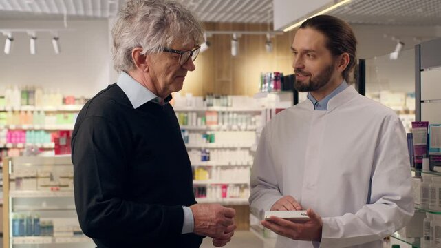 Caucasian doctor pharmacist consulting customer pills dosage advice at pharmacy men medical professional assistance talking to old senior patient pharmaceutical help cardiac drugs vitamins health care