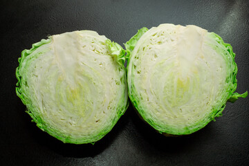 Fresh green cabbage with a half on a black background.
Fresh ripe cabbage. Vegetarianism. The...