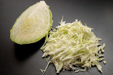 Fresh green cabbage cut into strips on a black background.
Fresh ripe cabbage. Shredded cabbage....