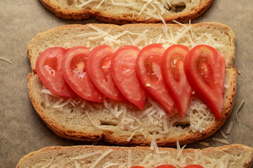 Close-up of tomato bruschetta on artisan bread slices with fresh sliced ​​tomatoes, parmesan...