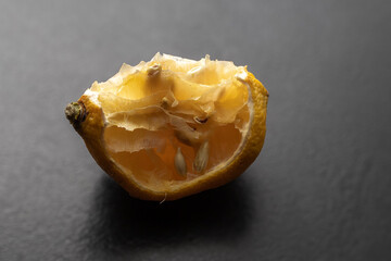 A piece of bad dry lemon isolated on black background.