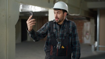 Caucasian man foreman builder talking mobile phone on construction site problem building stressed...
