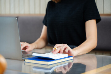 Close up of businesswoman or accountant hand typing laptop working to calculate on desk about cost