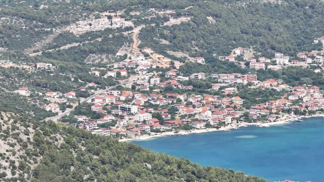 Drone captures winding and indented coastline between Poljica and Seget Vranjica with rocky shores, blue sea, and natural inlets under a sunny sky