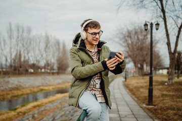 Young adult caucasian student smile and using smart phone to talk or take self portrait