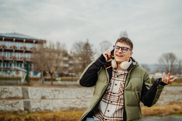Young adult caucasian student smile and using smart phone to talk or take self portrait