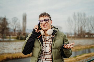 Young adult caucasian student smile and using smart phone to talk or take self portrait