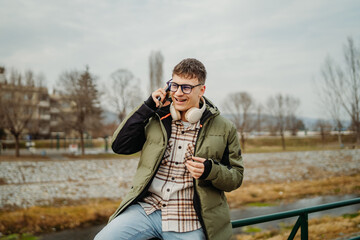 Young adult caucasian student smile and using smart phone to talk or take self portrait