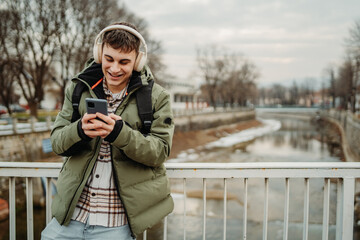 Young adult caucasian student smile and using smart phone to talk or take self portrait