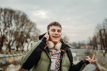 Young adult caucasian student smile and using smart phone to talk or take self portrait
