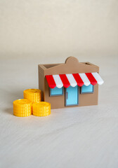 Money coins next to the store. Open your own business. Business pays taxes. Income and profit....