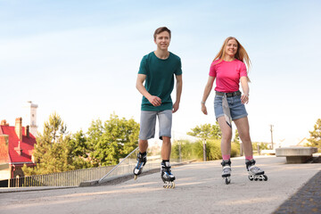 Happy couple roller skating together on street