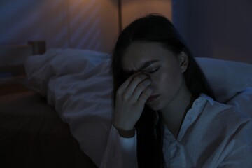 Frustrated woman suffering from insomnia at home, space for text