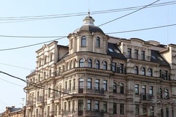 Modern Multi-Story Residential Building with Balconies in Urban Environment, Featuring Traffic Signs and Overhead Wires in Foreground