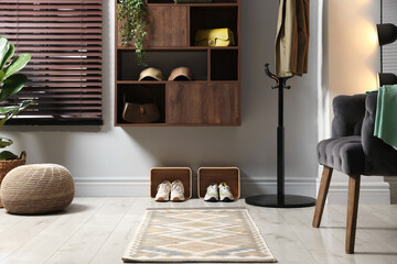Shelving unit with different accessories and shoes in hallway