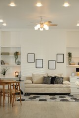 Comfortable sofa, table, chairs and dresser indoors. Interior design