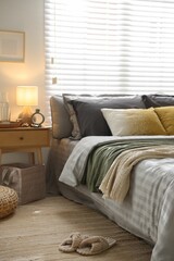 Comfortable bed with soft linens and blankets in room. Home textile