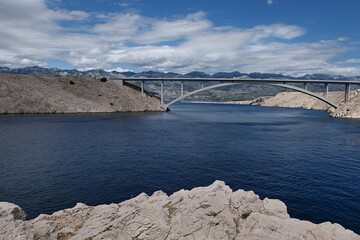 Coastal landscape with Pag bridge landmark, as seen from Fortica fortress nearby, partially cloudy summer skies during mid july season 2025. 