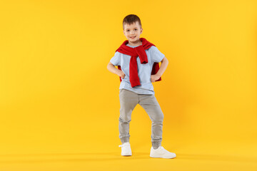 Happy little boy dancing on orange background