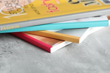 Stack of different magazines on grey table, closeup