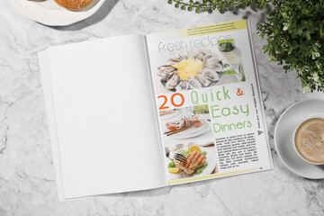 Open magazine, coffee and plant on white marble background, flat lay. Mockup for design