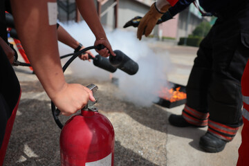Employees firefighting training, Concept Employees hand using fire extinguisher fighting fire closeup	
