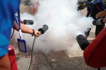 Employees firefighting training, Concept Employees hand using fire extinguisher fighting fire closeup	
