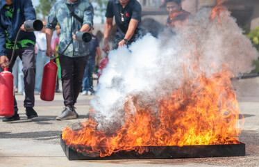 Employees firefighting training, Concept Employees hand using fire extinguisher fighting fire closeup	
