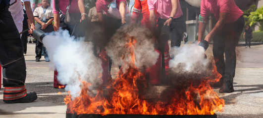 Employees firefighting training, Concept Employees hand using fire extinguisher fighting fire closeup	
