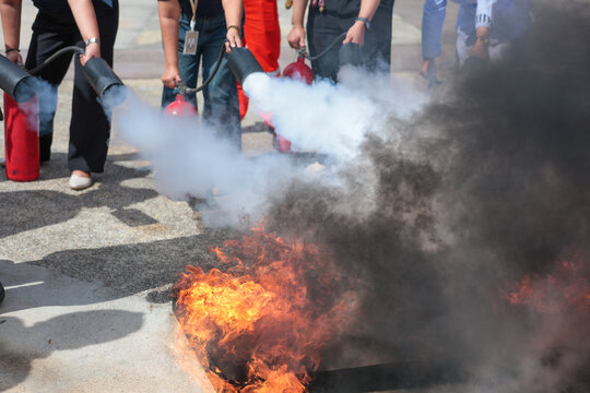 Employees firefighting training, Concept Employees hand using fire extinguisher fighting fire closeup	
