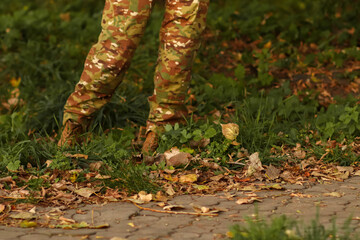 A Ukrainian military woman or man in camouflage uniform, marching through an autumn landscape, representing national intelligence and disciplined service
